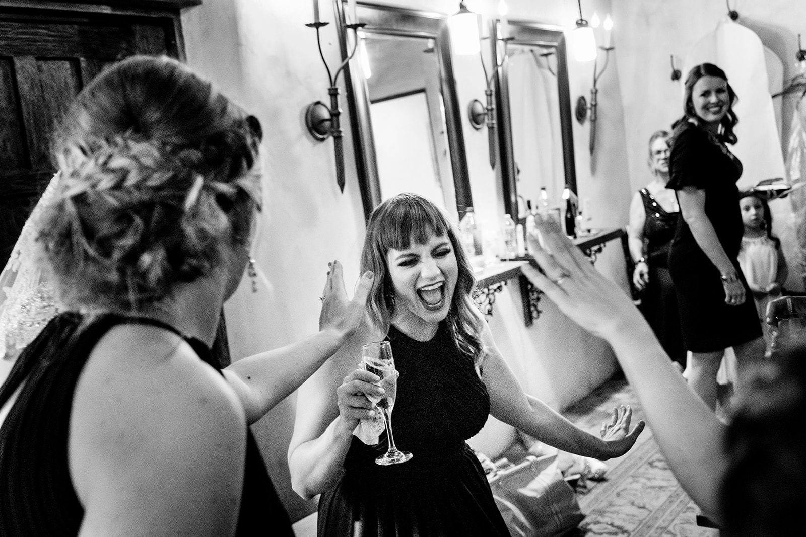 Bride and bridesmaids dancing while getting ready